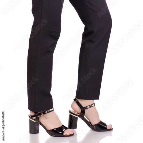 Female legs in classic black pants black lacquer shoes classic style