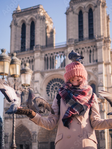 Girl feeding pigeons in the square in front of the cathedral of Notre Dame