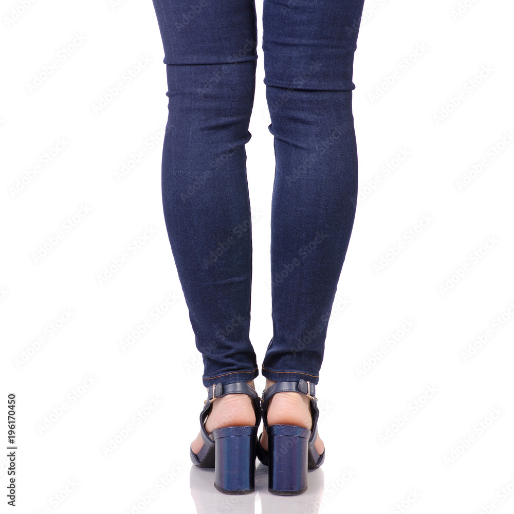 Female legs in jeans and in blue sandals shoes Female legs in jeans and in blue sandals shoes