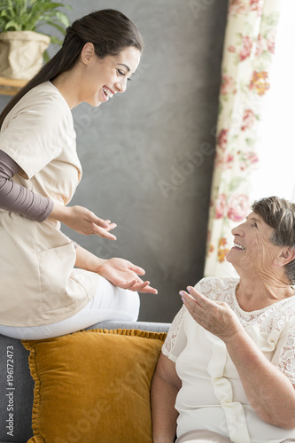 Senior woman conversating with caregiver photo