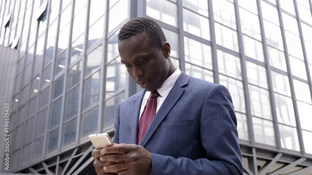 handsome African Black young man in the street tyoing on his smartphone- outdoor handsome African Black young man in the street tyoing on his smartphone- outdoor