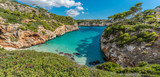Panoramic view of Es calo des Moro beautiful beach. Pine trees shadows on the crystalline water. Clasified as one of the best beaches in the world. Located in Majorca, Balearic Islands, Spain.