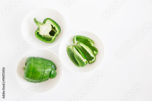 Sliced bell pepper on the white plates.fresh green vegetable.white background.minimalistic styling image