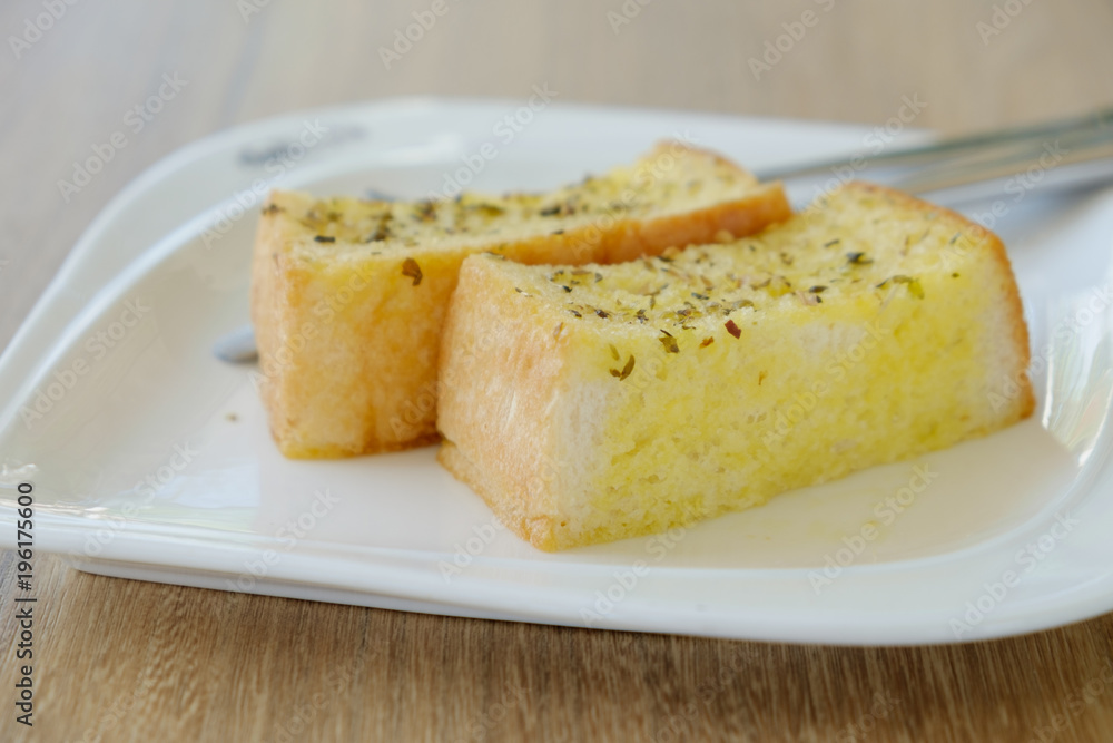 Delicious Garlic bread on white plate.