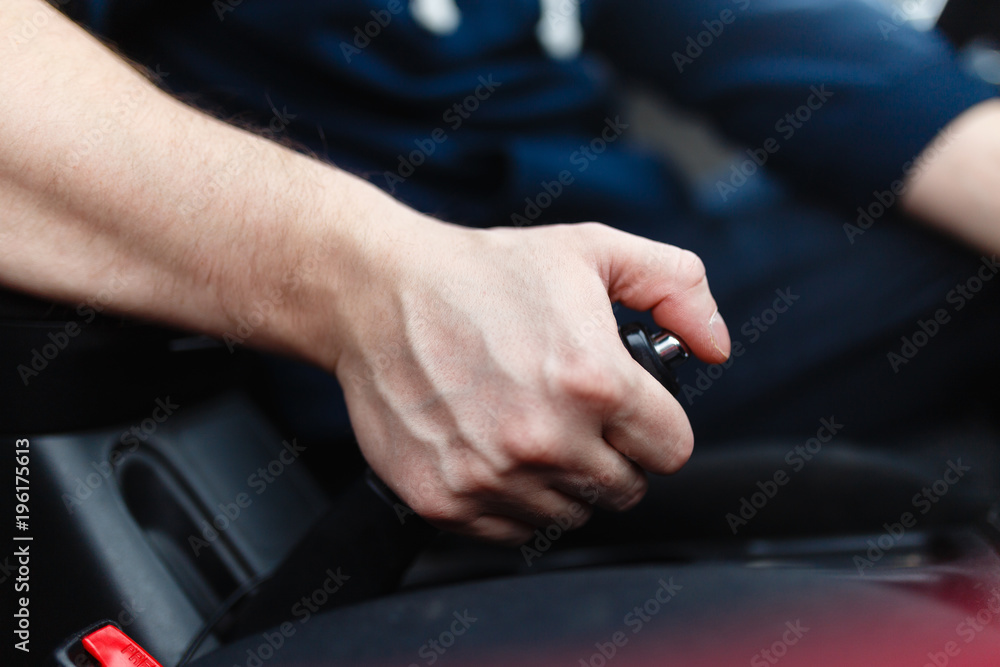 The driver pulls the hand brake lever. Male hand pulling the Parking brake using the hand brake lever. Hand brake for emergency stopping.