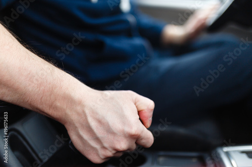 The driver pulls the hand brake lever. Male hand pulling the Parking brake using the hand brake lever. Hand brake for emergency stopping. © korchemkin
