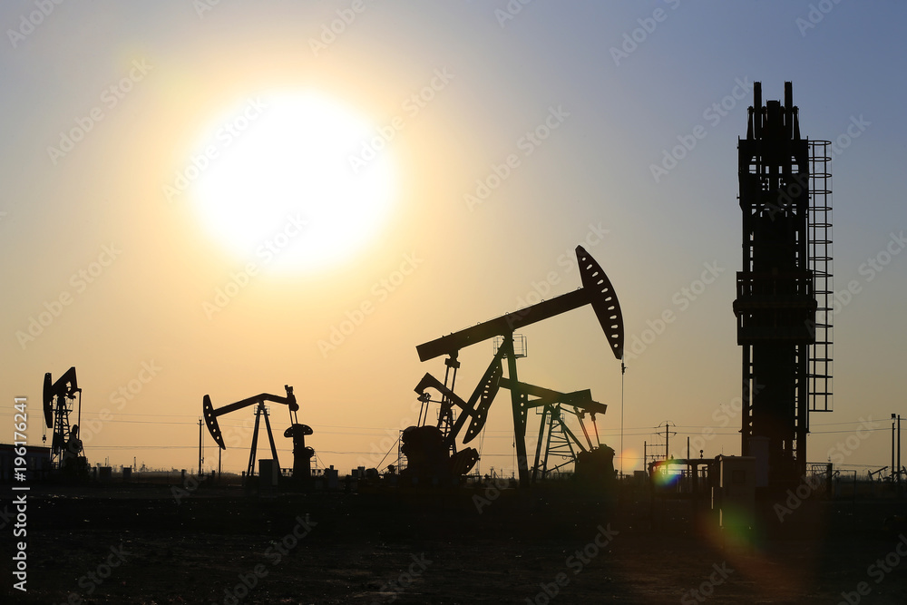 The pumping unit is working in the setting sun The pumping unit is working in the setting sun