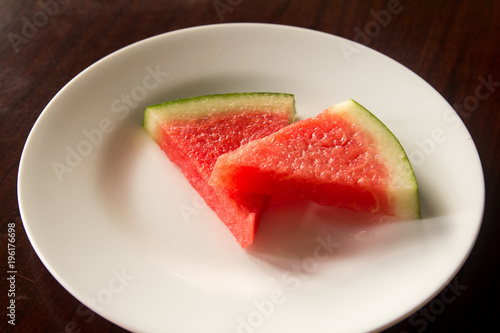 Slice of delicious watermelon on white plate background