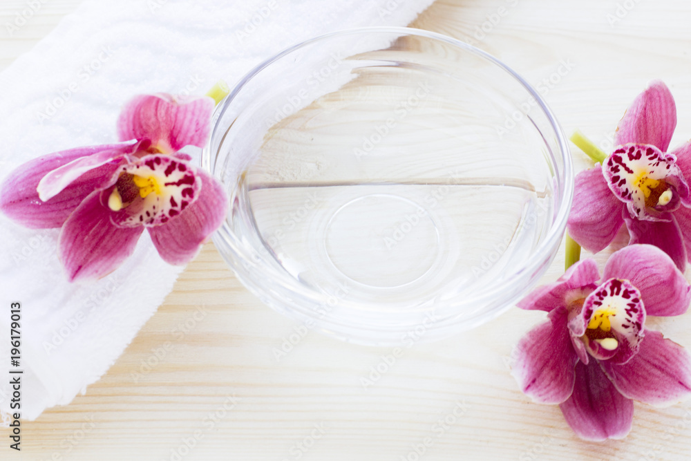 Spa and wellness setting with orchid, oil on wooden white background closeup Spa and wellness setting with orchid, oil on wooden white background closeup