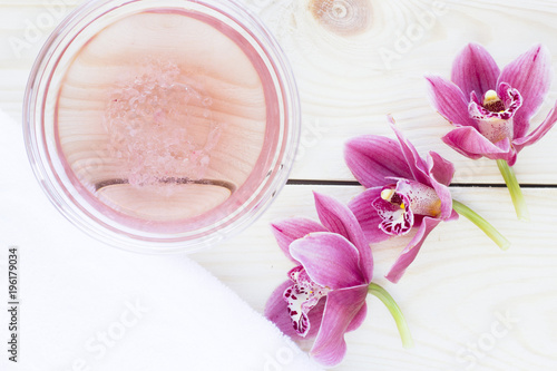 Spa and wellness setting with orchid, oil on wooden white background closeup