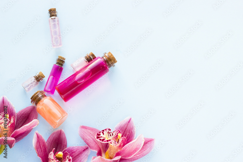 Spa and wellness setting with orchid and bottles with oil on blue background copyspace Spa and wellness setting with orchid and bottles with oil on blue background copyspace
