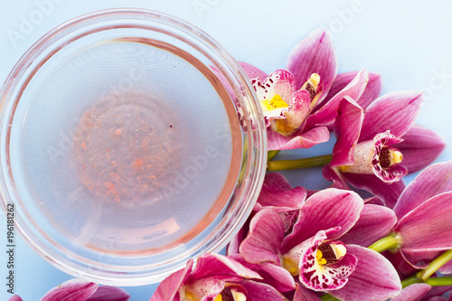 Spa and wellness setting with orchid and oil on blue background copyspace