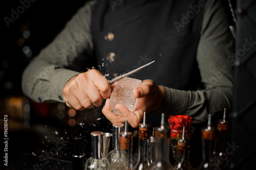 Barman preparing a large rectangular piece of ice