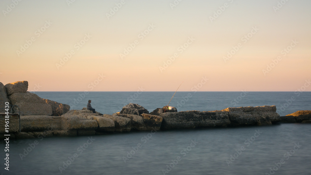 Rocks in the calm sea at sunset