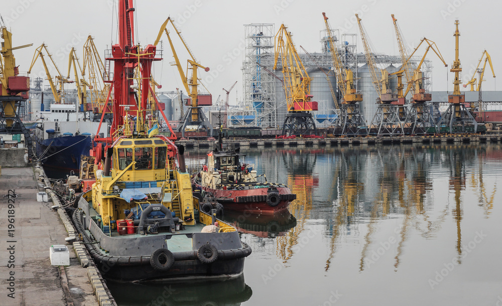 Sea cargo port. Tug, floating crane, dry cargo ship and other infrastructure of the port. Sea cargo port. Tug, floating crane, dry cargo ship and other infrastructure of the port.