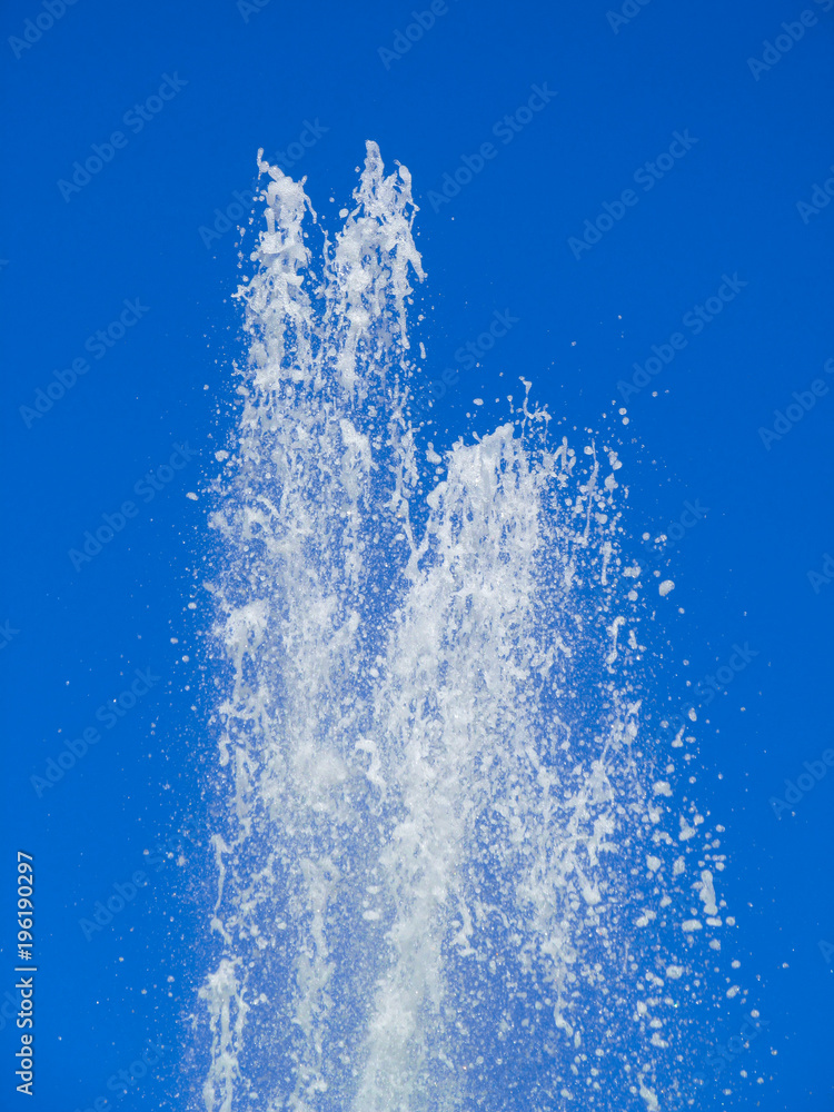 White water jet on blue clear sky background.
Abstract fountain splashing with waterfall drops. Purity and freshness concept.