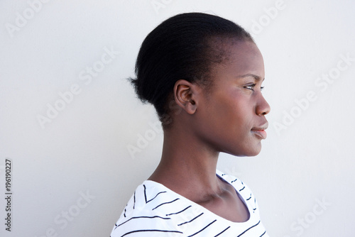 Close up profile young black woman against white wall
