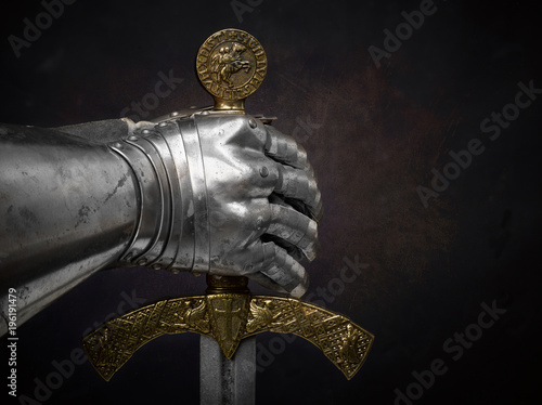 фотографія A beautiful ancient sword of the Order of the Knights Templar and an iron knight's glove