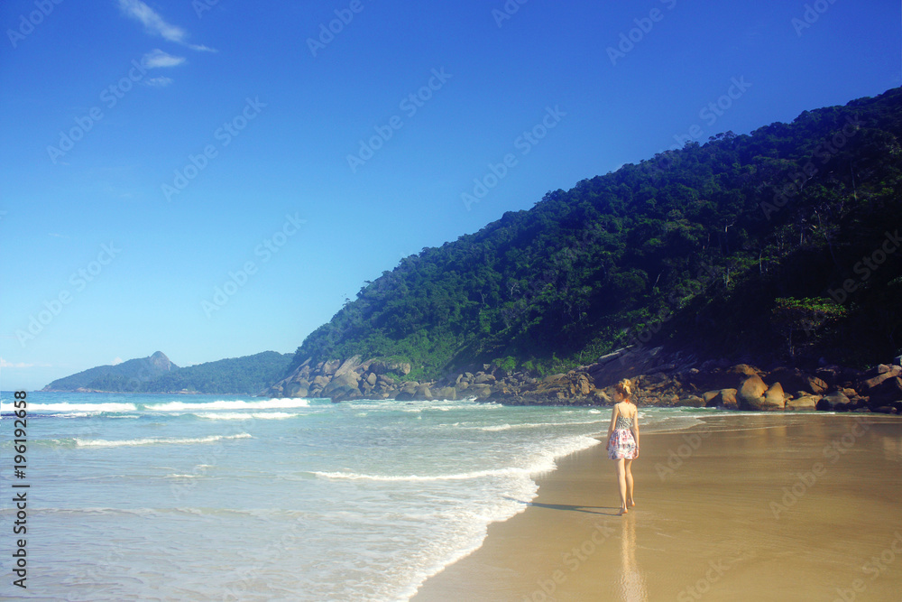 young woman in skirt walking along the seashore, Brazil young woman in skirt walking along the seashore, Brazil
