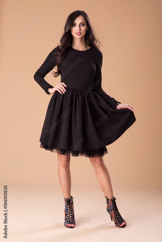 Fototapeta premium Beautiful fashionable woman in a elegant black dress, handbag and accessories. Fashion spring summer photo