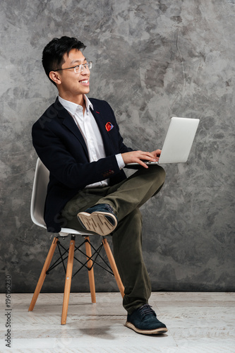 Full length portrait of a happy young asian man