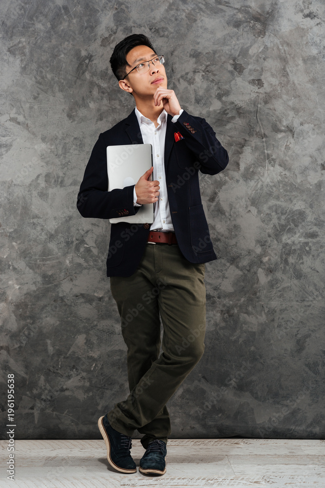 Full length portrait of a pensive young asian man Full length portrait of a pensive young asian man