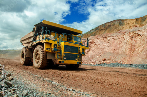 the dump truck transports iron ore. Colorful quarry.
