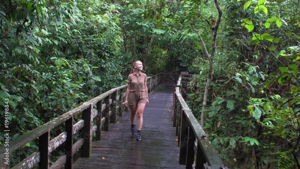 Female Tourist Walking in Rainforest Park Female Tourist Walking in Rainforest Park