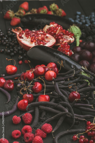 Collection of fresh purple and red fruit and vegetables on the black vintage color