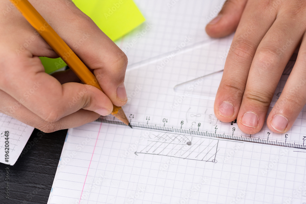 Mathematics Concept. Schoolboy Hands with Ruler Drawing on White Paper.