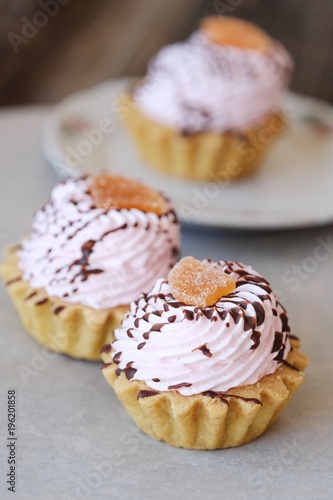 Delicious cakes with berry cream and chocolate sauce