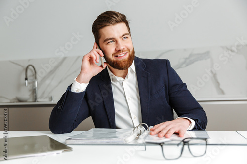 Portrait of a cheerful young businessman dressed in suit