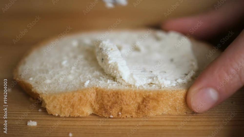 Man spreading butter on rye dry toast with a knife. Person spreading creamy butter on a piece of bread. Close up of male hands spreading butter on bread in kitchen, slow motion. Man spreading butter on rye dry toast with a knife. Person spreading creamy butter on a piece of bread. Close up of male hands spreading butter on bread in kitchen, slow motion.