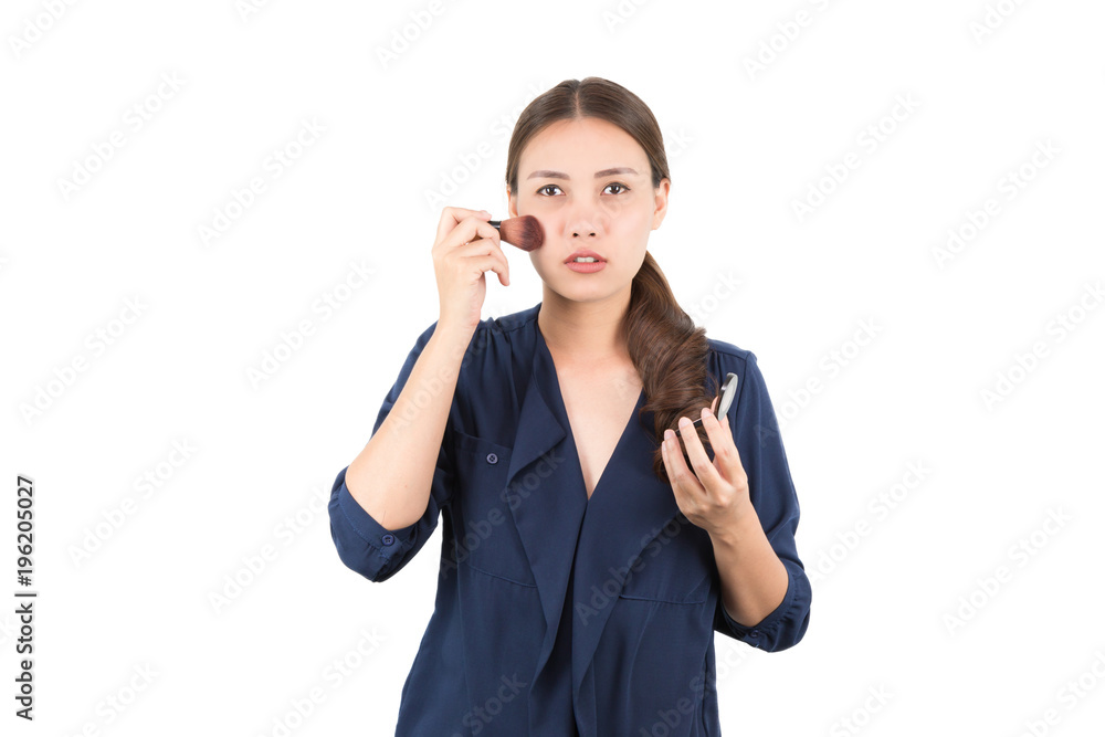 Portrait of beautiful Asian woman holding a powder brush and applying makeup cosmetic with big makeup brush on her face skin and cheek by herself isolated on white background. Portrait of beautiful Asian woman holding a powder brush and applying makeup cosmetic with big makeup brush on her face skin and cheek by herself isolated on white background.