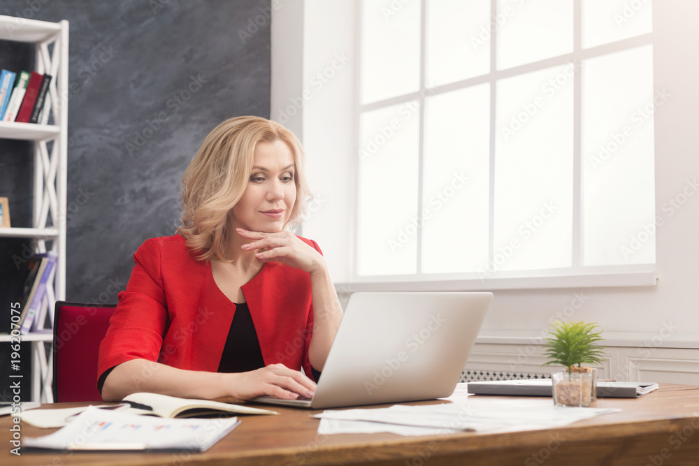 Concentrated businesswoman working on laptop at office Concentrated businesswoman working on laptop at office