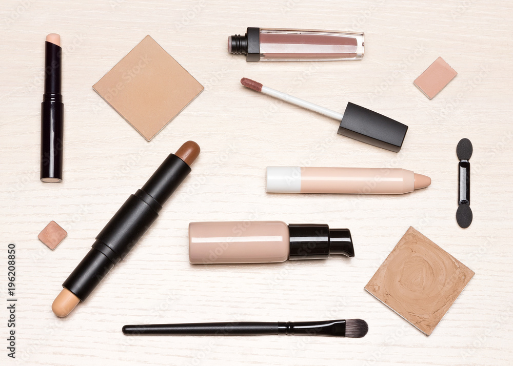 Basic makeup cosmetic products on light wood table flat lay Basic makeup cosmetic products on light wood table flat lay