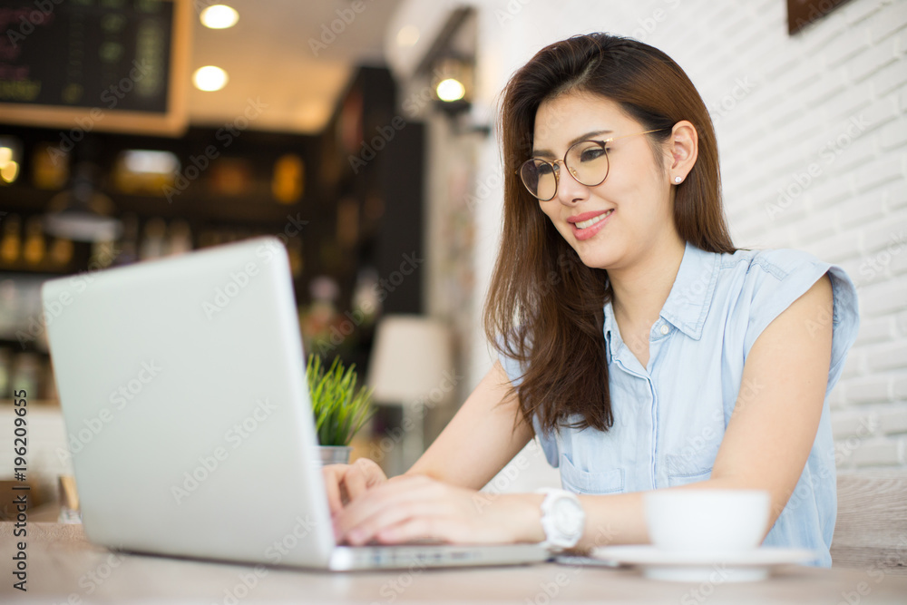 woman works at laptop in a cafe, woman's fingers typing on the keyboard. Workplace in a cafe, a cup of coffee next to a laptop, toned bright sunny photo woman works at laptop in a cafe, woman's fingers typing on the keyboard. Workplace in a cafe, a cup of coffee next to a laptop, toned bright sunny photo
