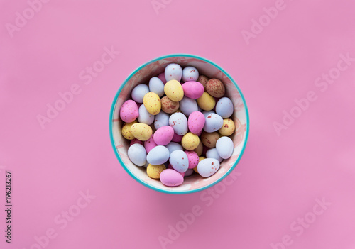 Easter chocolate colorful candy eggs on a pink background