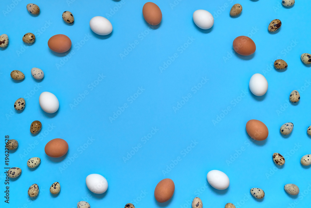 Frame of white, brown and quial eggs on blue background, copy space. Healthy food concept. Top view, flat lay. Easter eggs. Happy Easter concept Frame of white, brown and quial eggs on blue background, copy space. Healthy food concept. Top view, flat lay. Easter eggs. Happy Easter concept