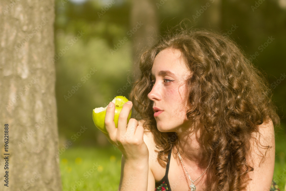 Young pretty woman eating apple on a field Young pretty woman eating apple on a field