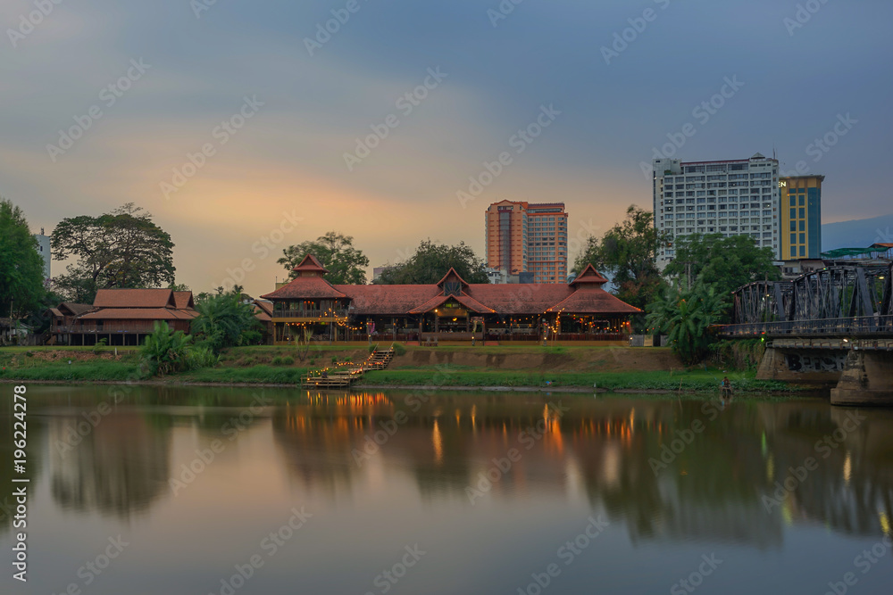 City and building on sunset time. The shadow of building showing on the river. and in font of is river passing.