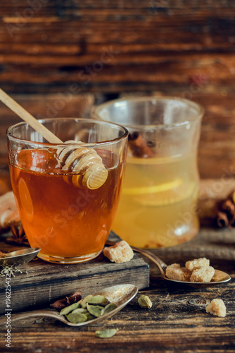 Vitamin medicinal tea with lemon and honey, ginger and spices on wooden background . The concept of spring beriberi and colds.