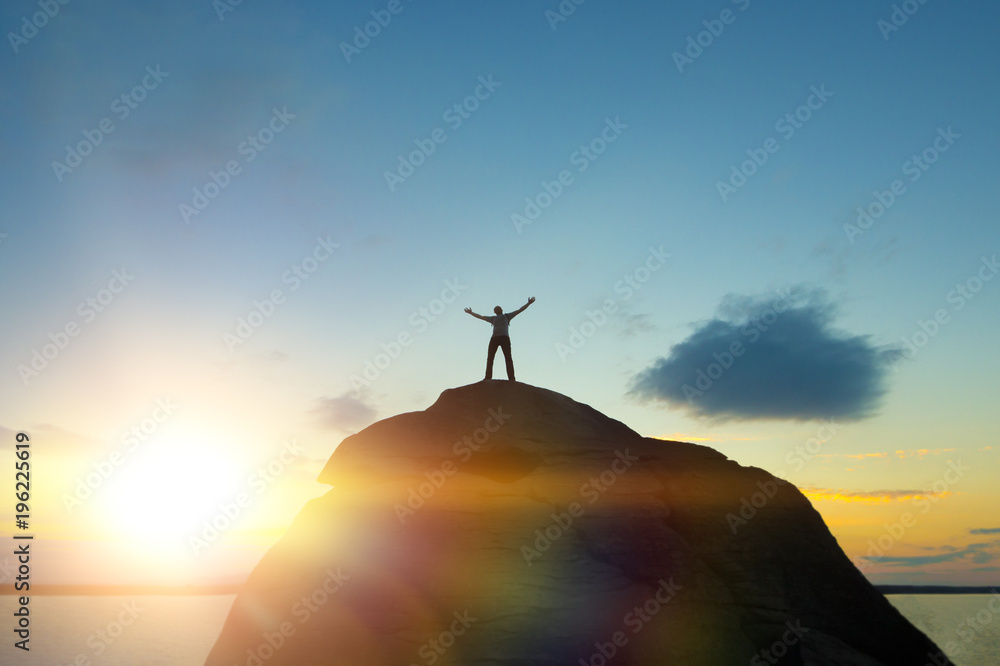 Silhouette of Man Celebrating Success Happiness on a mountain top Evening Sky Sunset Background, Sport and active life Concept. Success in business