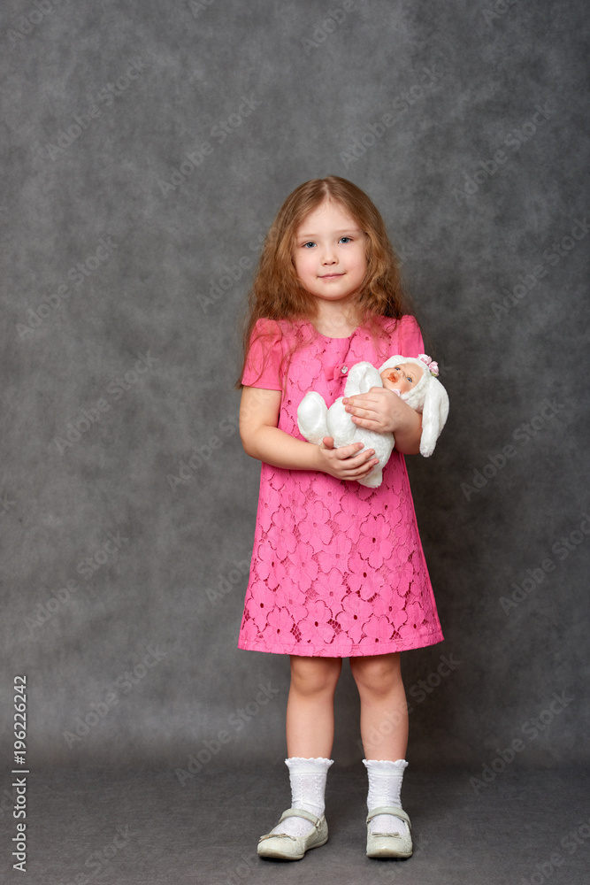 Girl in pink dress hugging white stuffed toy Girl in pink dress hugging white stuffed toy