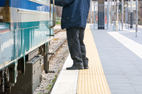 Horizontal View of a Man Standing near a Train at the Railway Station on Blur Background