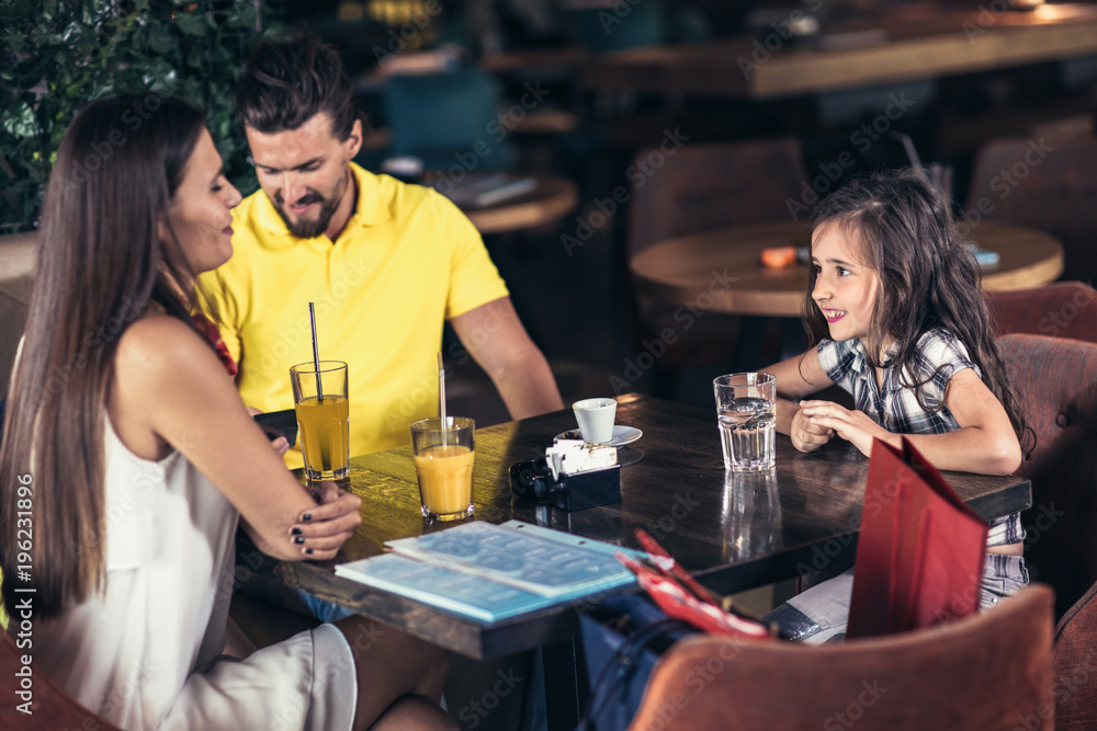  Family with two children having great time in a cafe after shopping