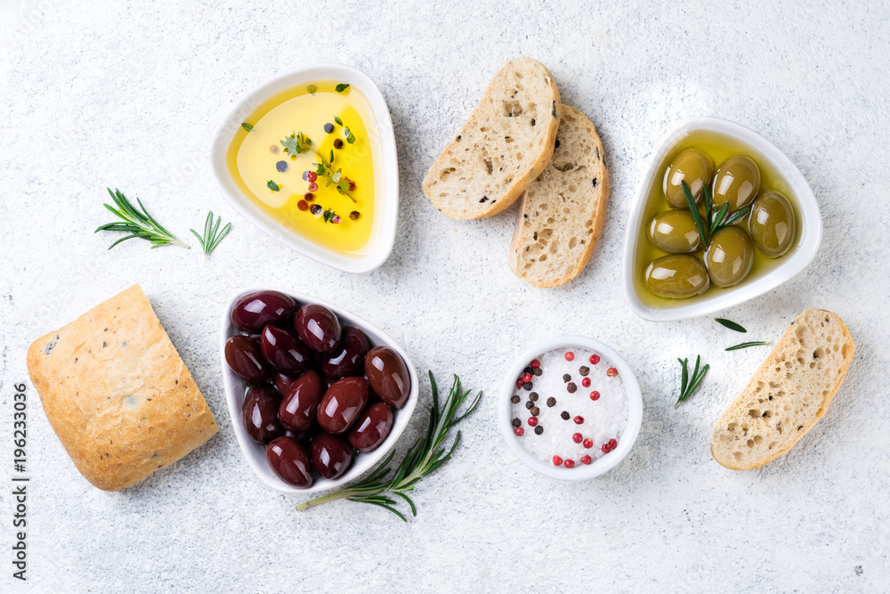 Ciabatta bread, olives, oil, herbs and spices on white background. Mediterranean or italian snacks. Top view