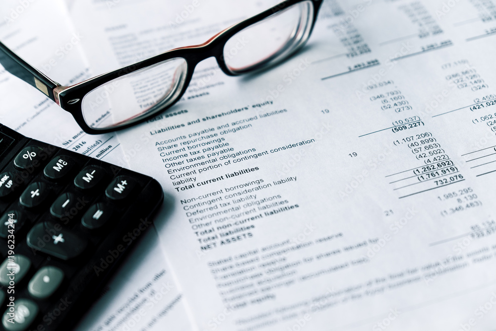 Financial statement and eyeglass, business concept, document is mock-up Financial statement and eyeglass, business concept, document is mock-up