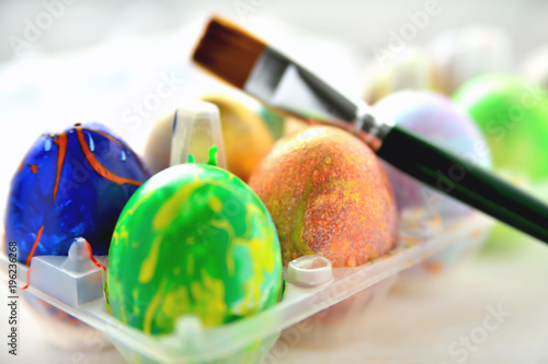 Colored eggs in a transparent box and an art brush