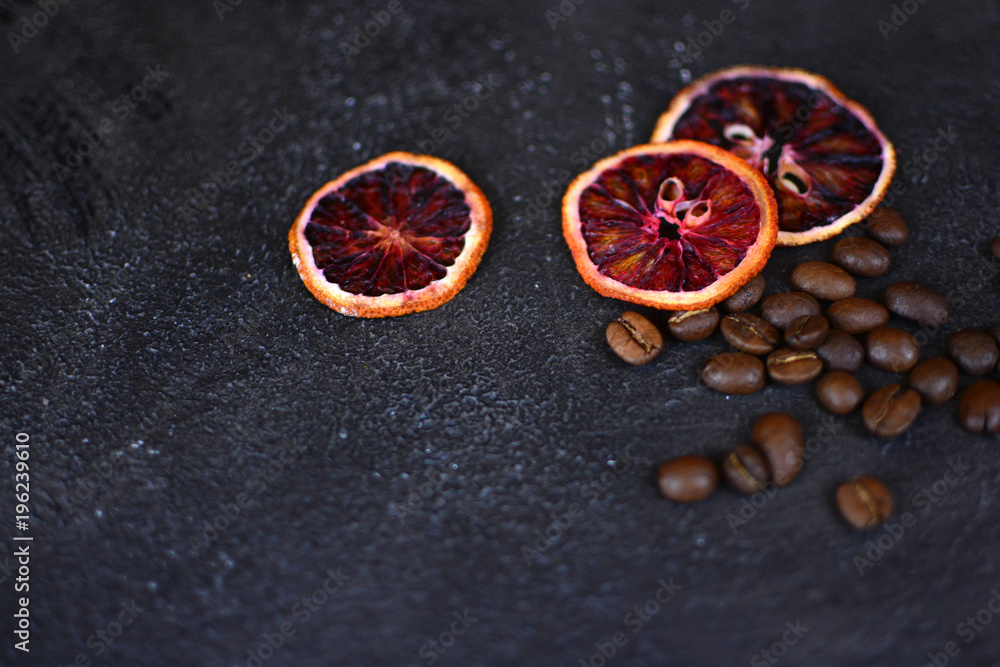 Beautiful and tasty background for design. Dried red orange slices with a coffee beans on a stone background. Cuisine wallpaper. Beautiful and tasty background for design. Dried red orange slices with a coffee beans on a stone background. Cuisine wallpaper.